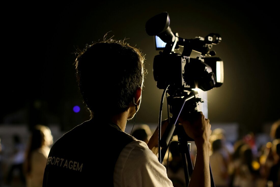 Camarógrafo grabando un evento con cámara profesional